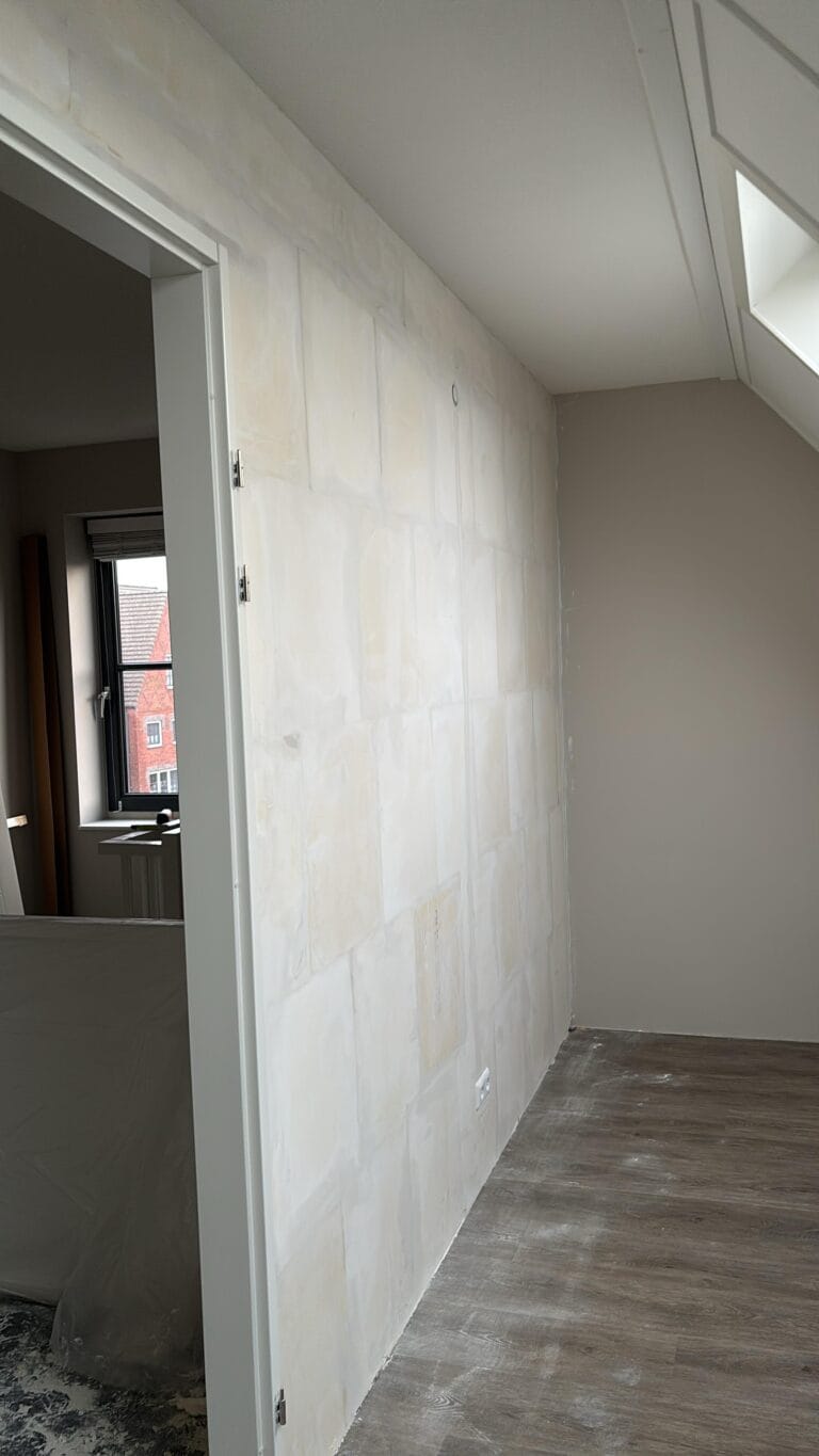Vakman plaatst strakke tussenwand van gipsplaten voor nieuwe indeling in woning