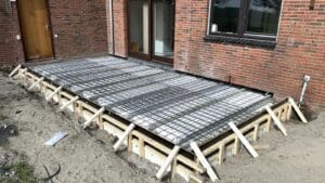 Aanbouw tegen schuur gedeelde fundering met contrabalken