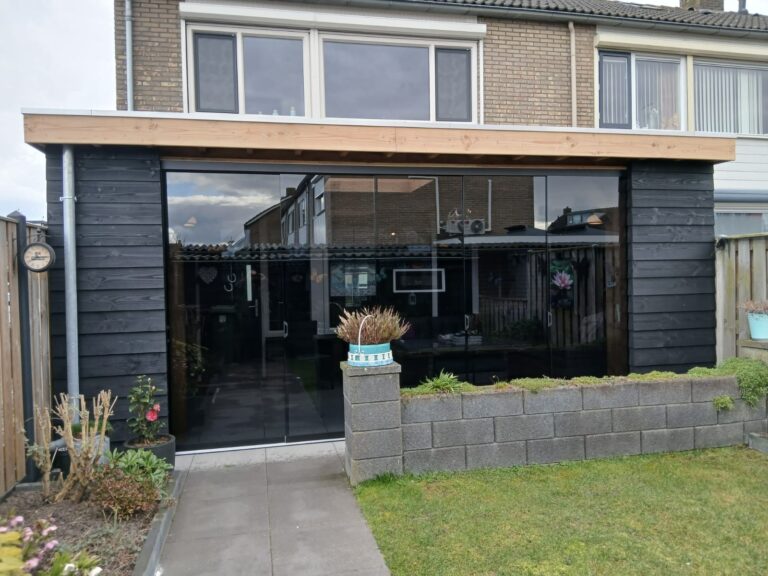 Moderne overkapping in Delft met houten constructie, zwarte gevelbekleding en glazen schuifwanden